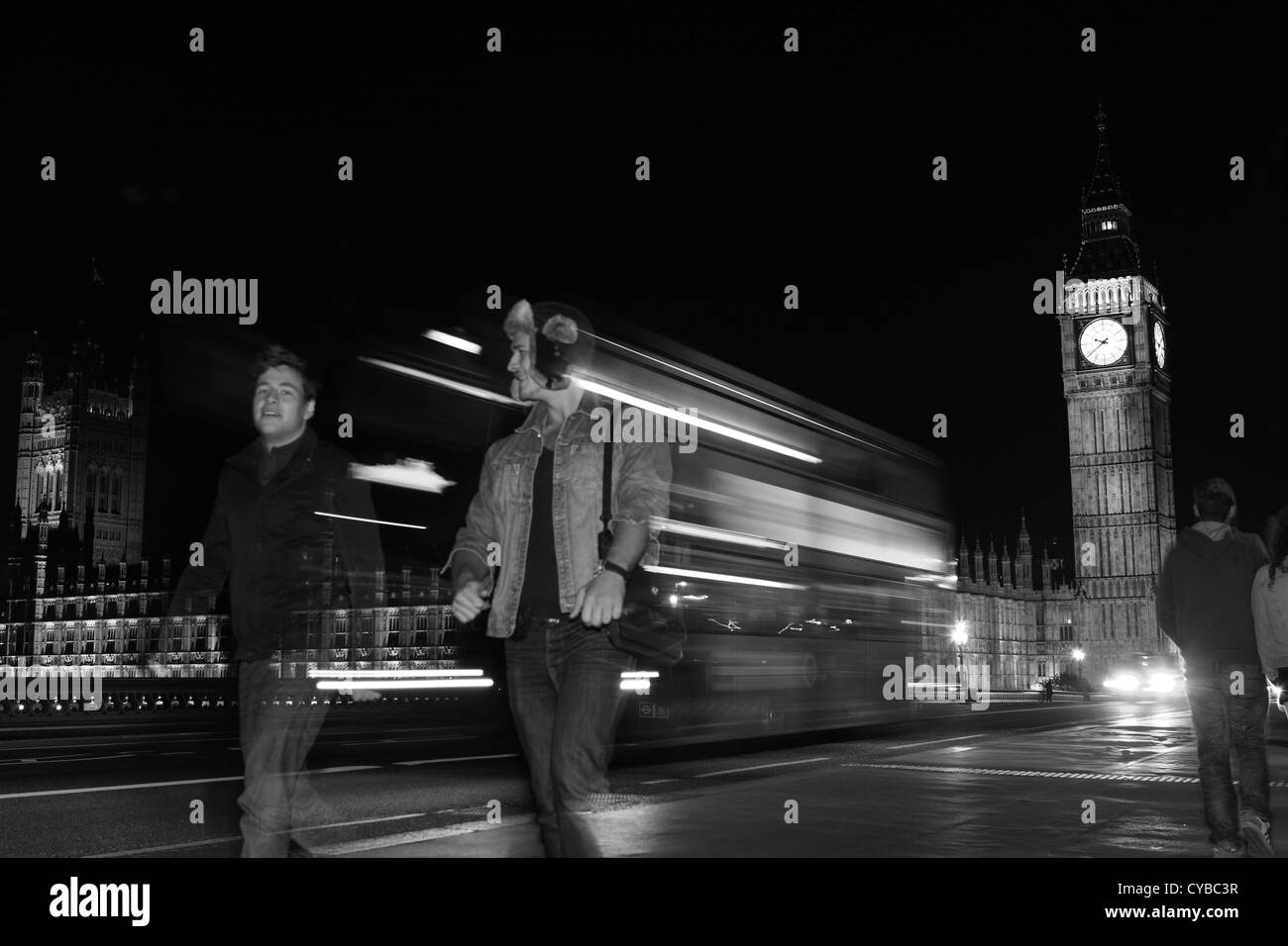 Una vista notturna di Westminster Bridge tra cui il Big Ben, persone e un double decker rosso London bus Foto Stock