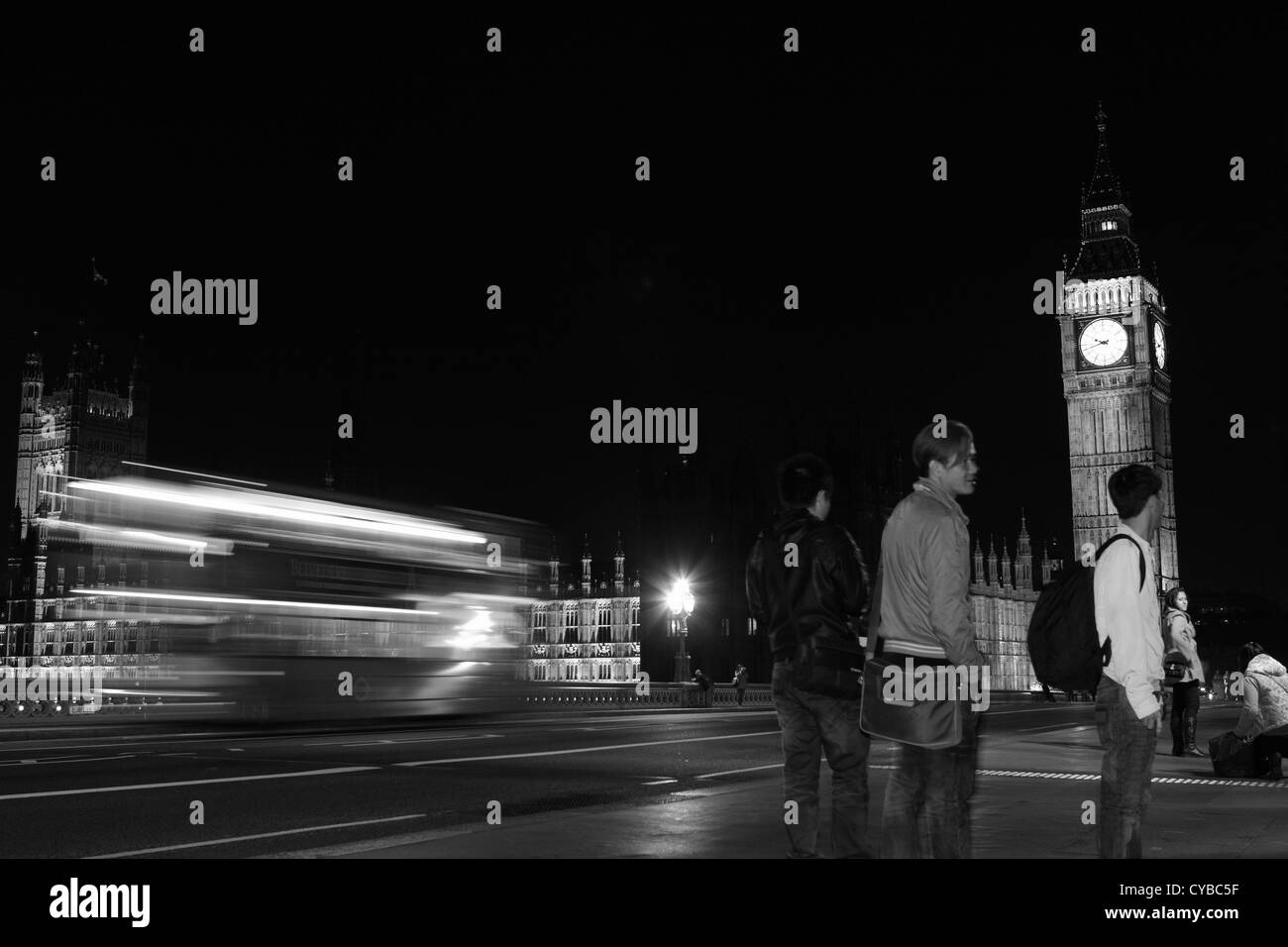 Una vista notturna di Westminster Bridge tra cui il Big Ben, persone e un double decker rosso London bus Foto Stock