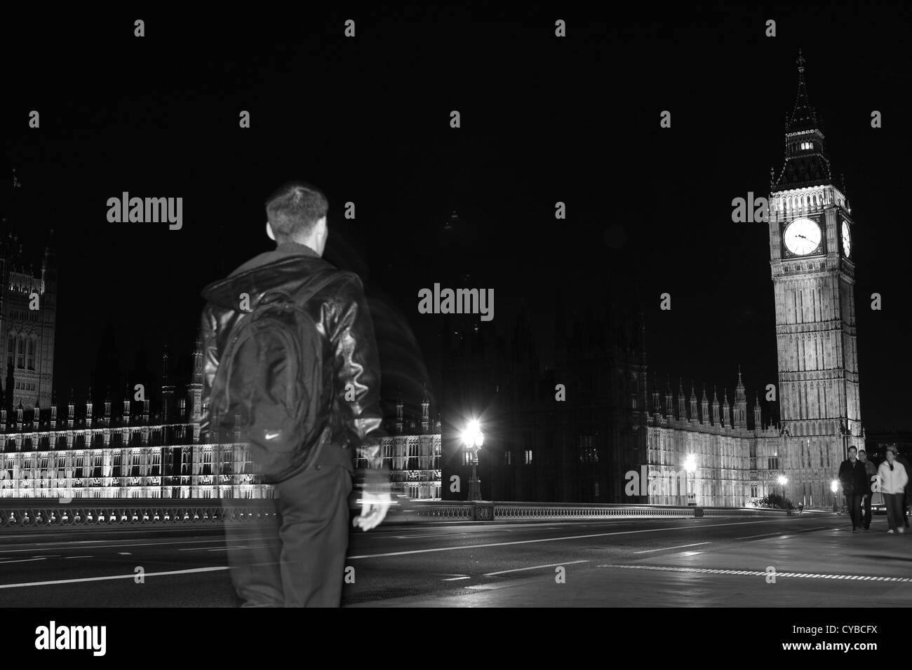 La gente che camminava sul Westminster Bridge, Londra, durante la notte con le case del Parlamento a distanza Foto Stock