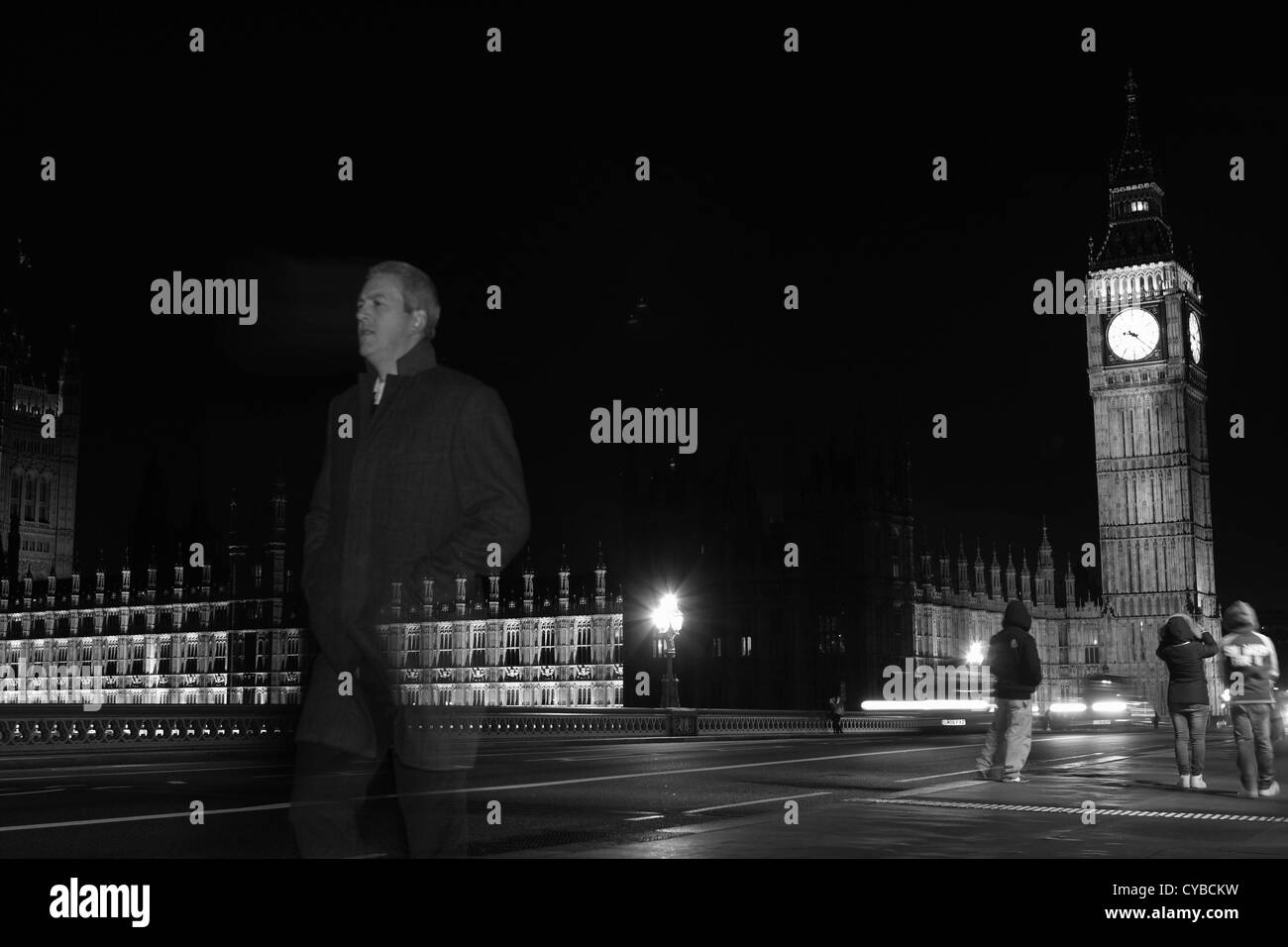 La gente che camminava sul Westminster Bridge, Londra, durante la notte con le case del Parlamento a distanza Foto Stock