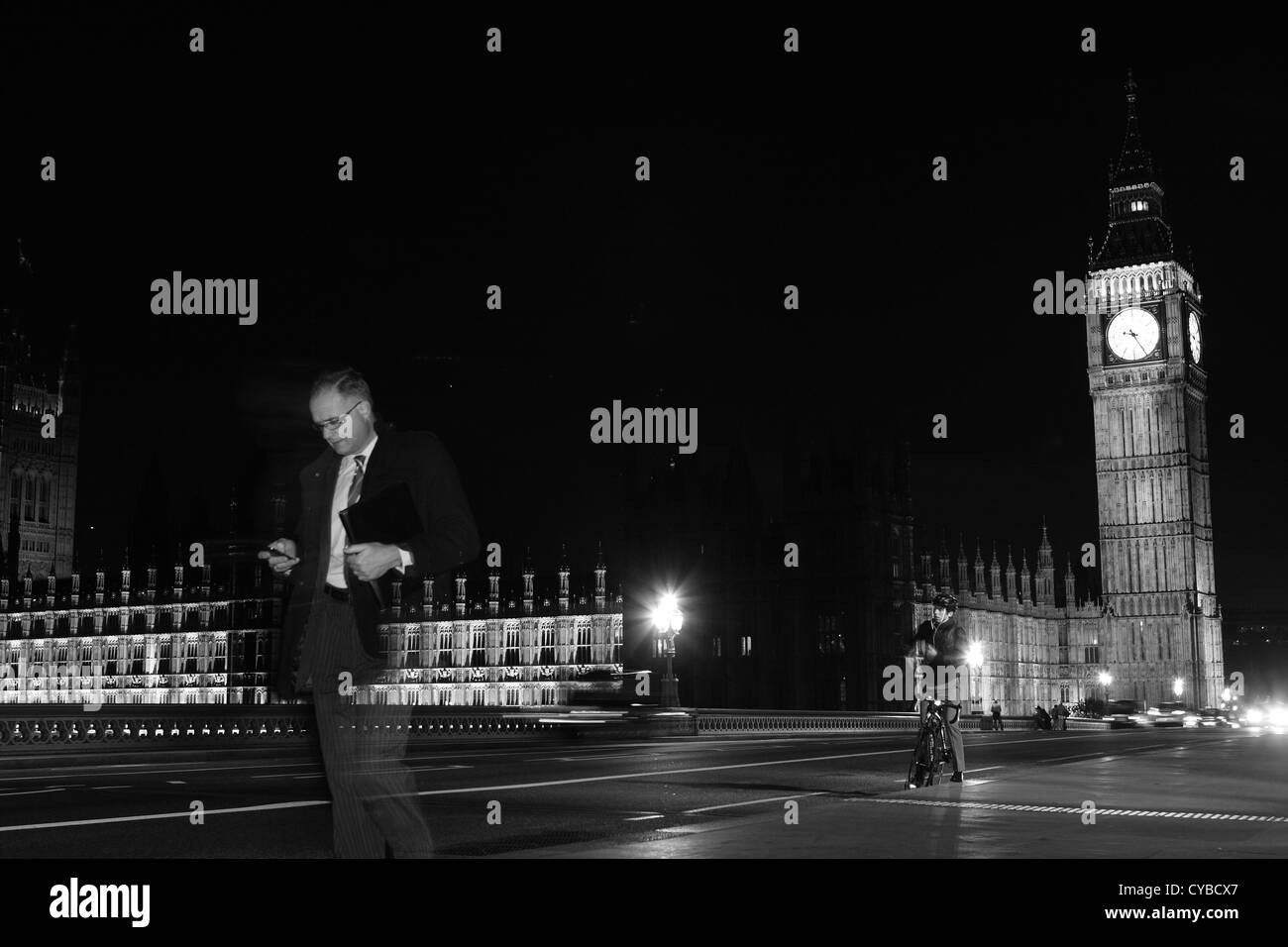 La gente che camminava sul Westminster Bridge, Londra, durante la notte con le case del Parlamento a distanza Foto Stock