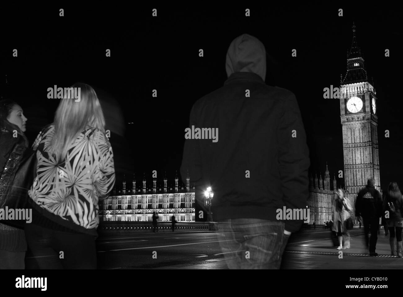 La gente che camminava sul Westminster Bridge, Londra, durante la notte con le case del Parlamento a distanza Foto Stock