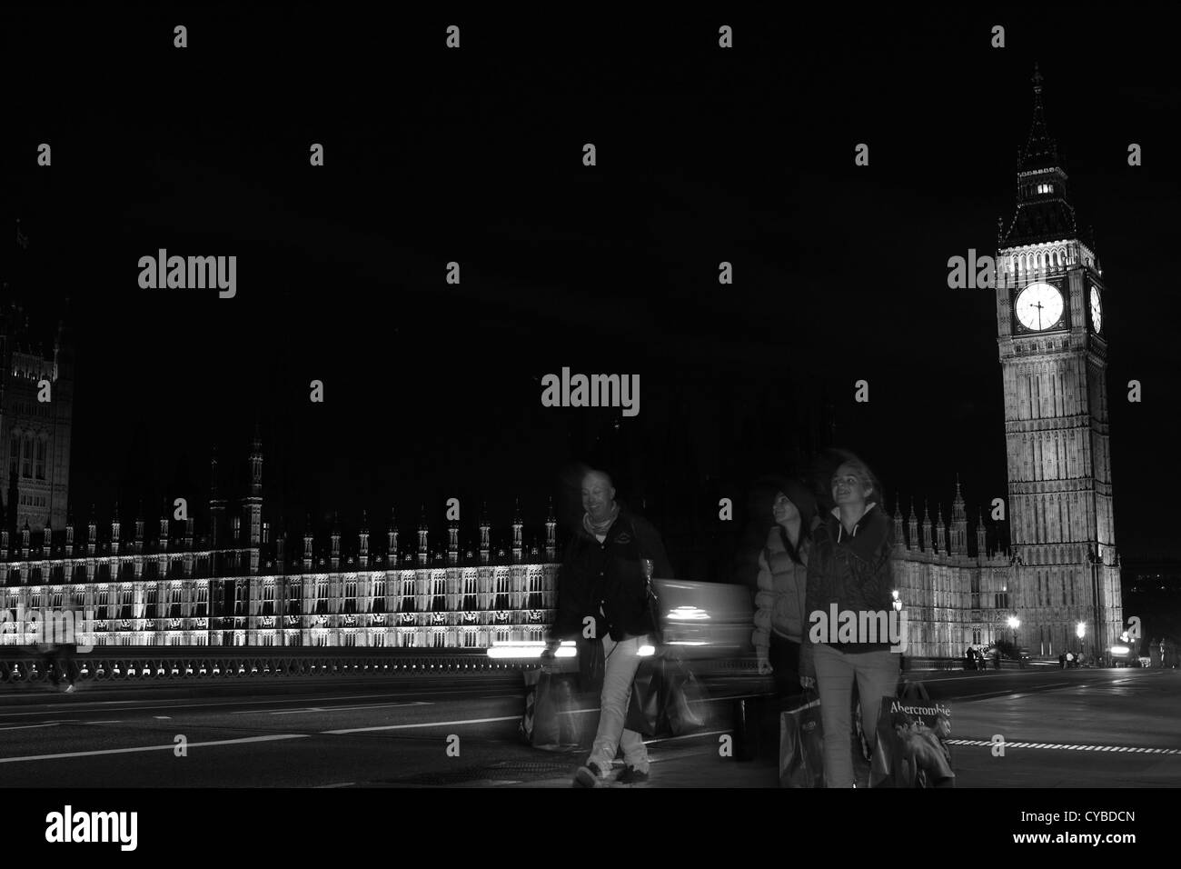La gente che camminava sul Westminster Bridge, Londra, durante la notte con le case del Parlamento a distanza Foto Stock