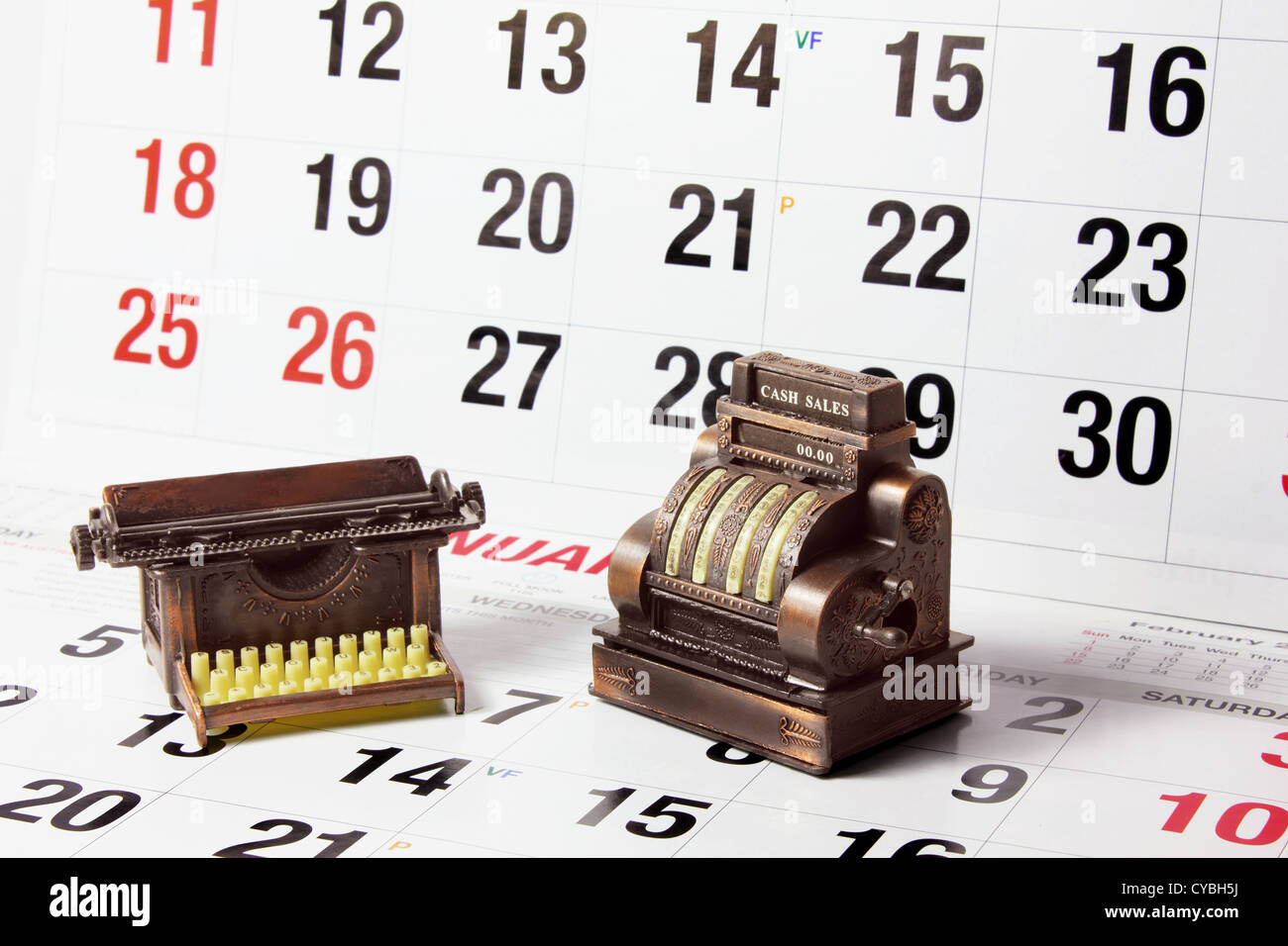 Miniatura registratore di cassa e i nastri inchiostratori per macchine da scrivere sulle pagine del calendario Foto Stock