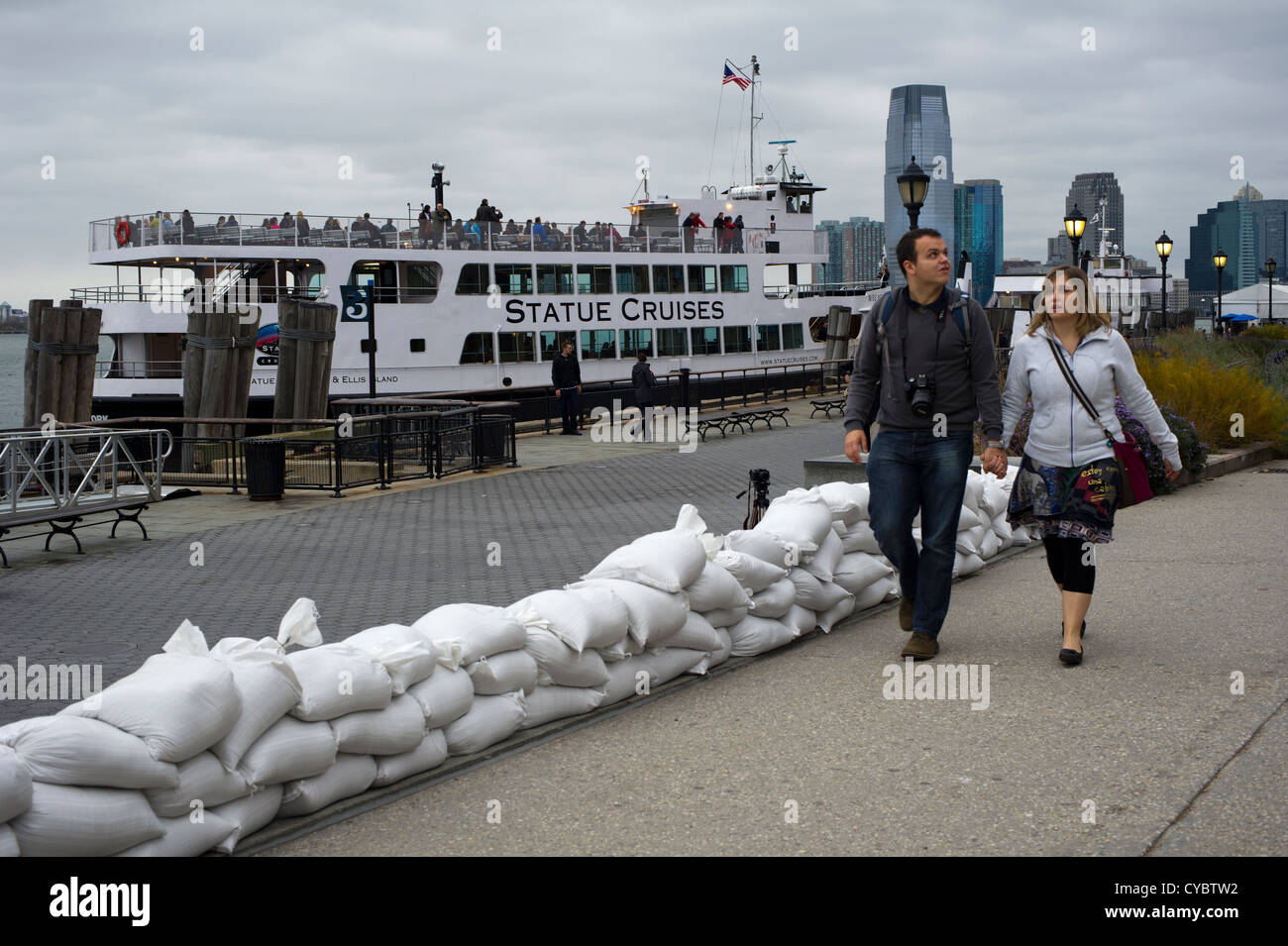 Fase di turisti su sacchi di sabbia al Liberty Island ferry in Battery Park nella zona a zona di evacuazione Foto Stock