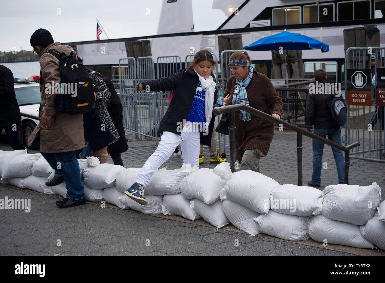 Fase di turisti su sacchi di sabbia al Liberty Island ferry in Battery Park nella zona a zona di evacuazione Foto Stock