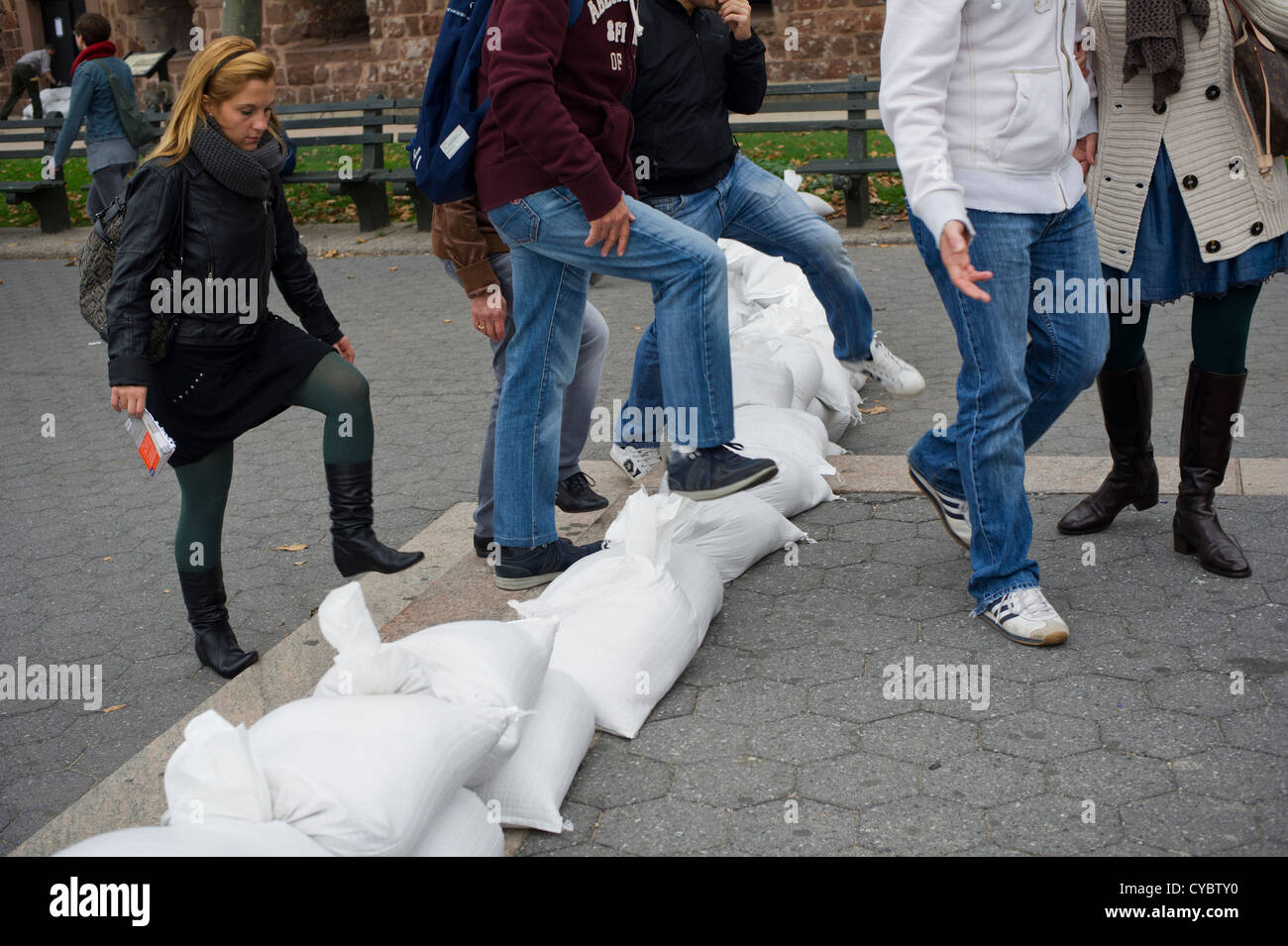 Fase di turisti su sacchi di sabbia al Liberty Island ferry in Battery Park nella zona a zona di evacuazione Foto Stock