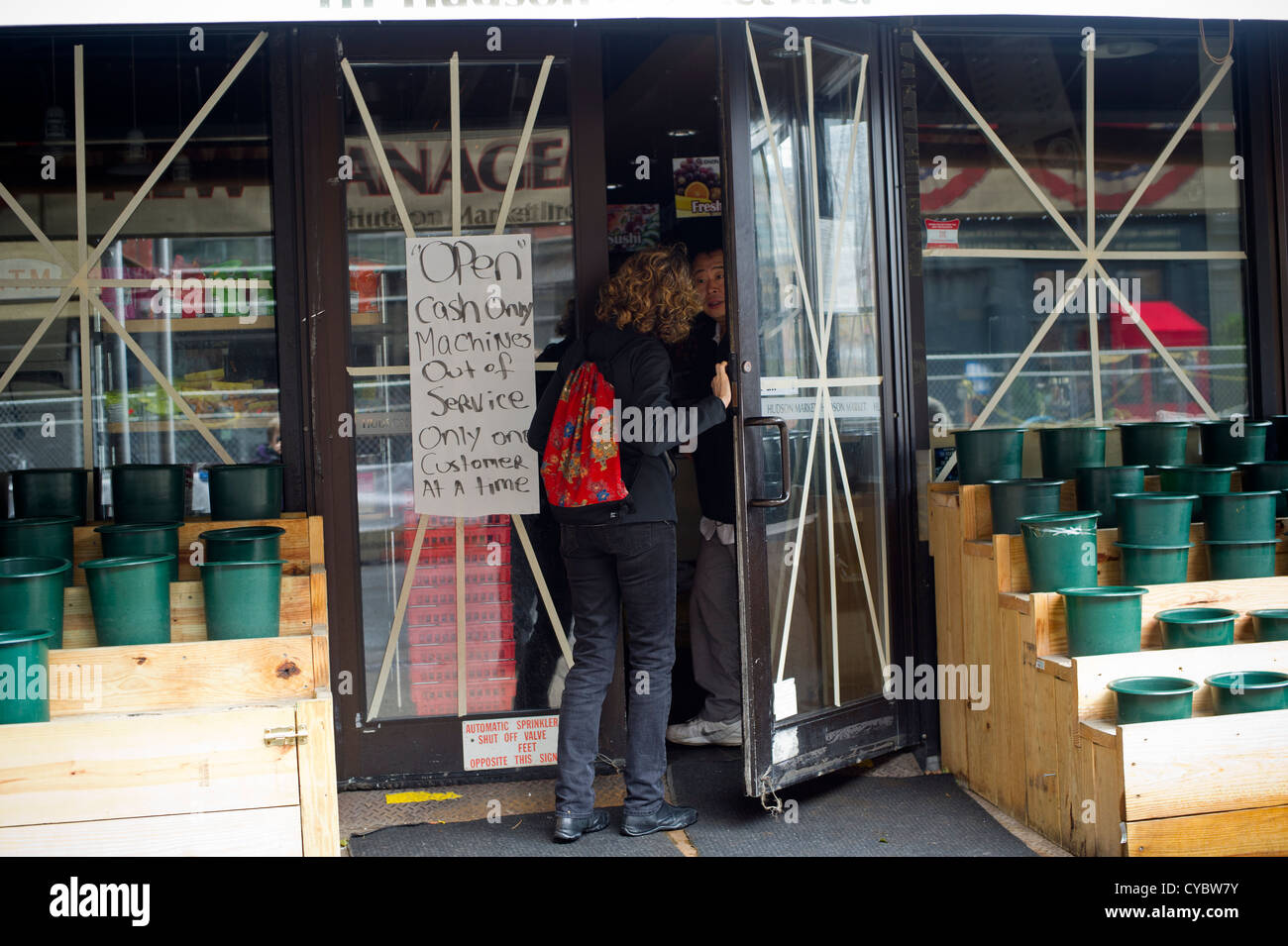 Un cliente è in attesa in linea in un deli, uno dei pochi aperti a causa dell'interruzione di alimentazione, nella New York quartiere di Tribeca Foto Stock