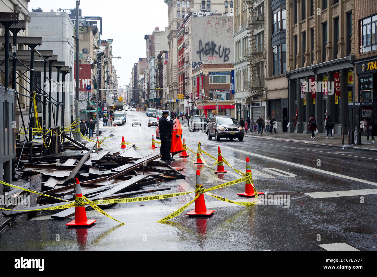 Un funzionario di NYPD custodisce una impalcatura collassato su Broadway in Manhattan inferiore dopo l uragano Sandy Foto Stock