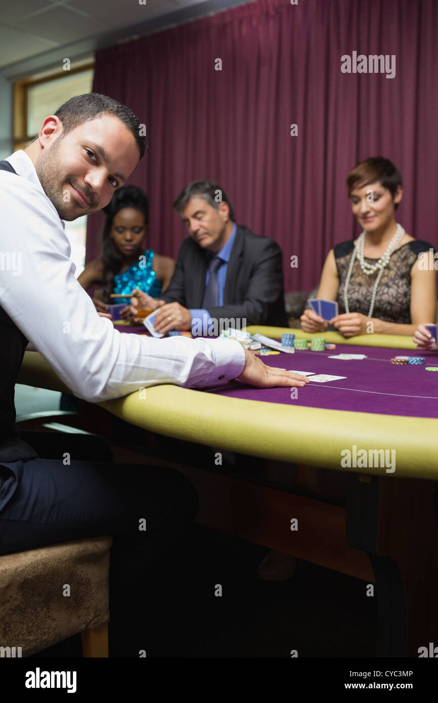 Concessionario sorridente al gioco di poker Foto Stock