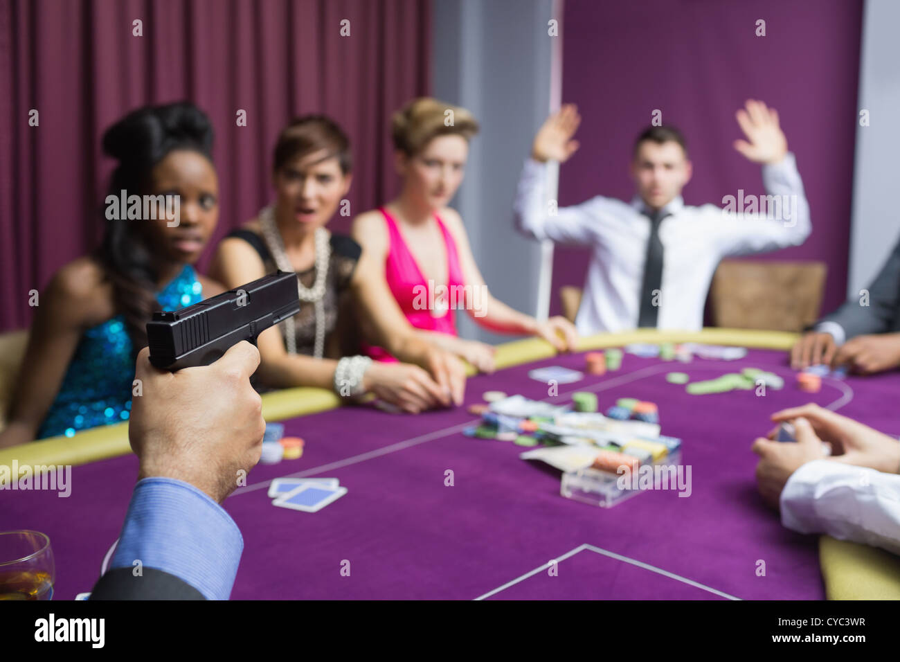 L'uomo puntando la pistola contro un altro uomo con le mani in alto Foto Stock