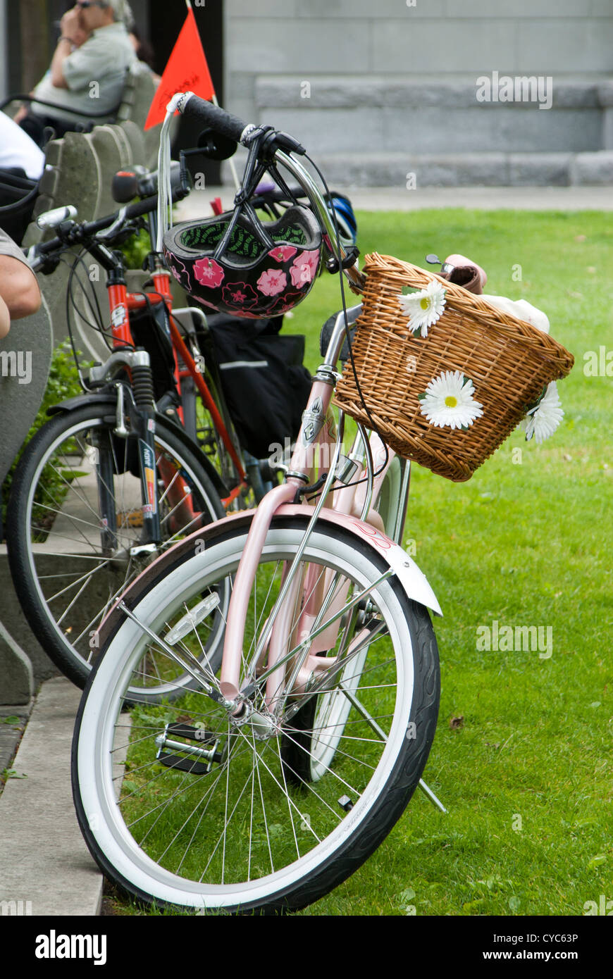 Bicicletta rosa con cesto in vimini e fiori su di esso Foto stock - Alamy