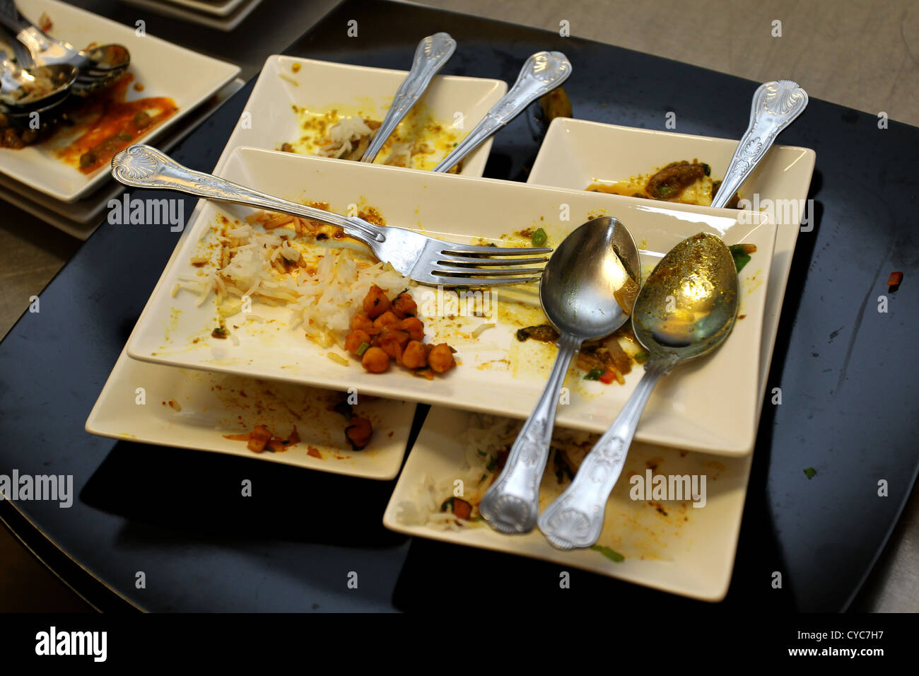 Una pila di piastre di sporco in un curry house in Brighton, East Sussex, Regno Unito. Foto Stock