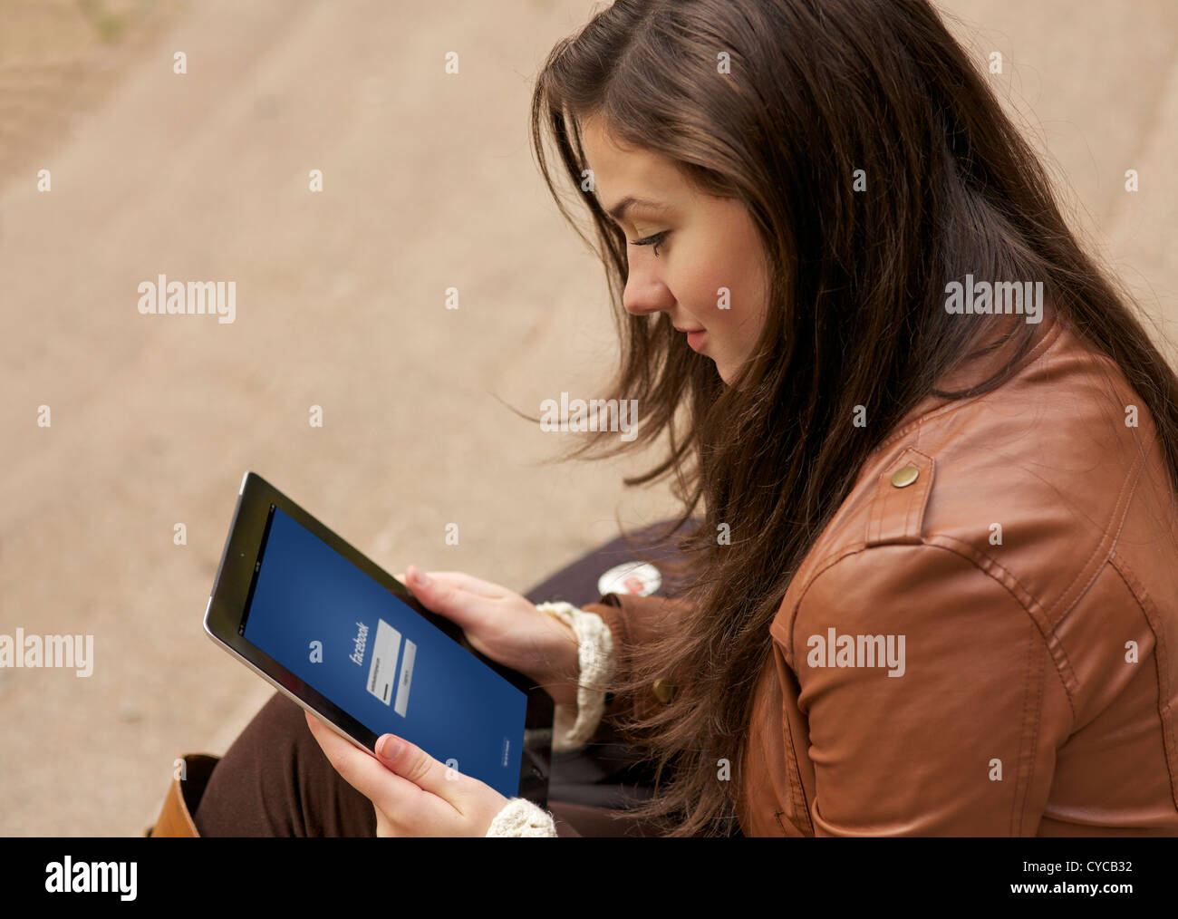 Chiudere l immagine di una giovane donna utilizzando Facebook sito di social networking su un iPad Foto Stock
