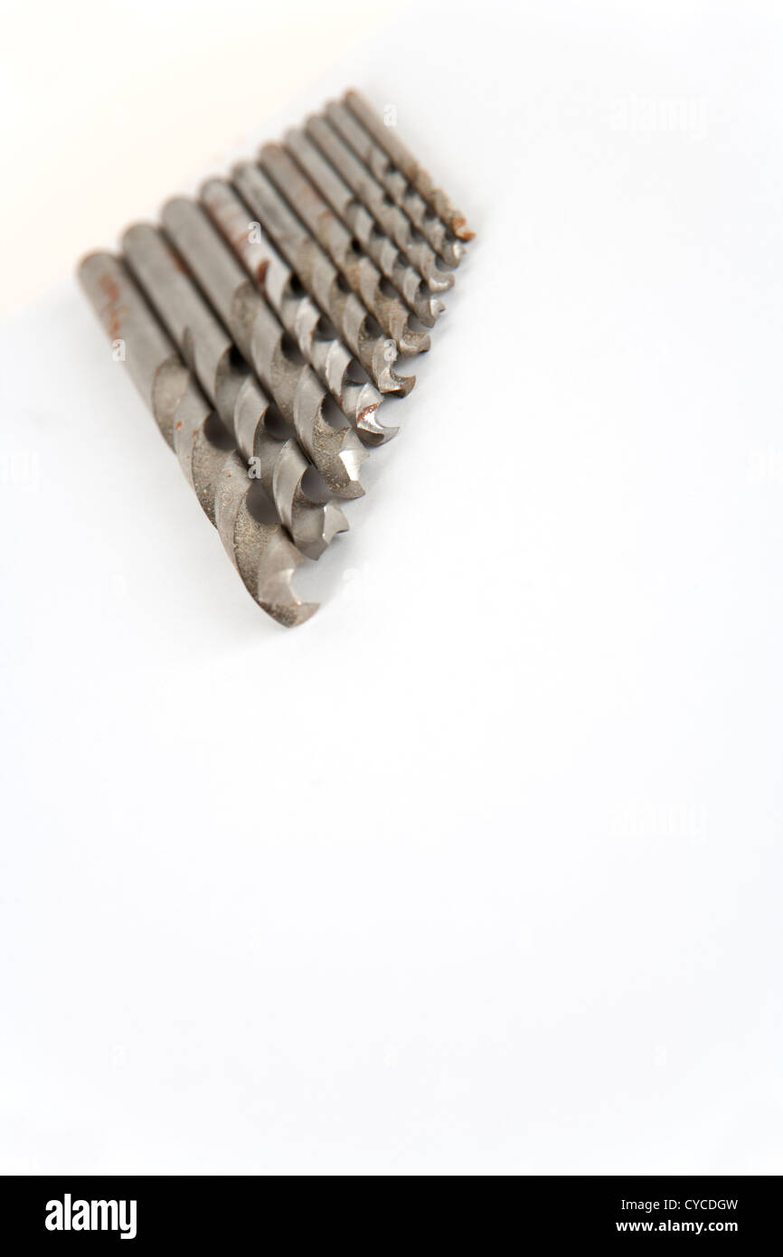 Ben utilizzati e la ruggine prestazioni twist punte da trapano su carta bianca con copia spazio. Profondità di campo. Foto Stock