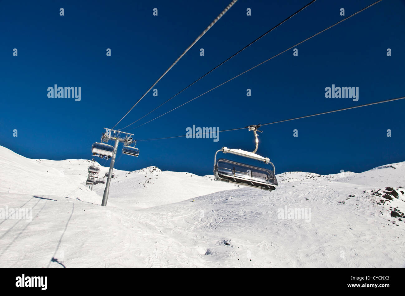 Svuotare ski lift, montagna innevata e cielo blu - Les Menuires, Alpi (Francia) Foto Stock