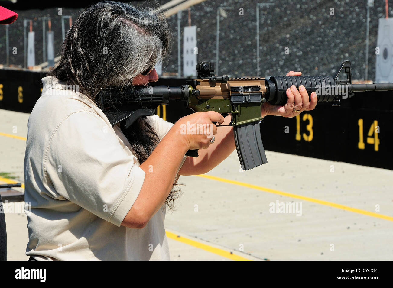 Prova Gunwoman sparare fucile automatico al FBI poligono di tiro a Chicago, Illinois, Stati Uniti d'America Foto Stock