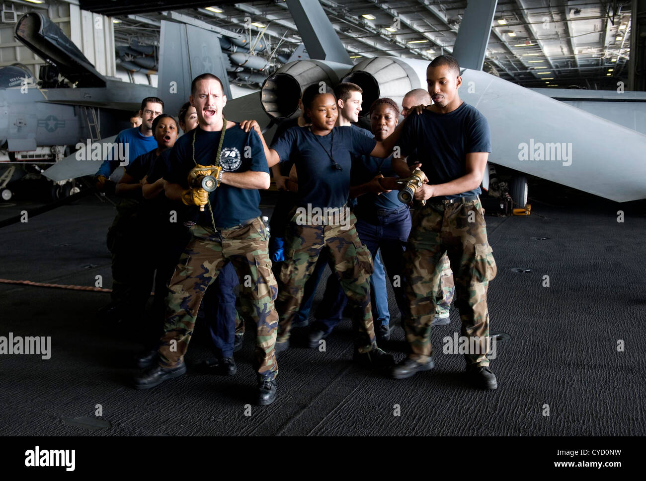 I marinai a bordo della USS John C. Stennis (CVN 74) rispondono ad un incendio simulato di un aereo nell'hangar Bay come parte del loro addestramento di routine. La nave è schierata nella zona della 5th Fleet degli Stati Uniti, conducendo operazioni di sicurezza e sostenendo missioni marittime. Foto Stock