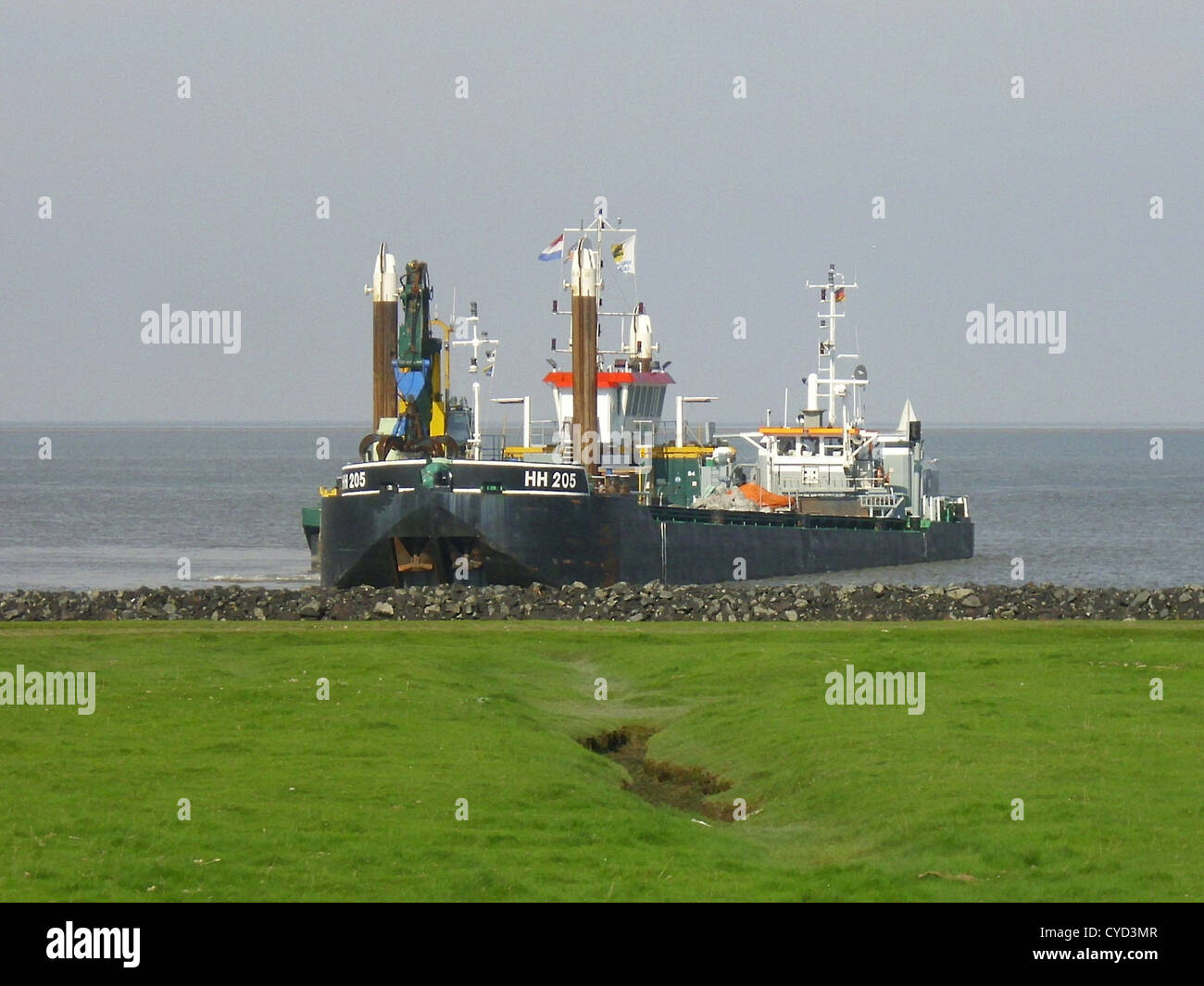 Il Prins 5, un pontile palafitte, trasporta un escavatore a bordo ed è visto accanto alla chiatta semovente HH 205 sul fiume Elba. Queste navi fanno parte delle operazioni di trasporto pesante, presentando attrezzature marittime specializzate per la costruzione e le attività di scavo lungo il fiume tra Cuxhaven e Otterndorf. Foto Stock