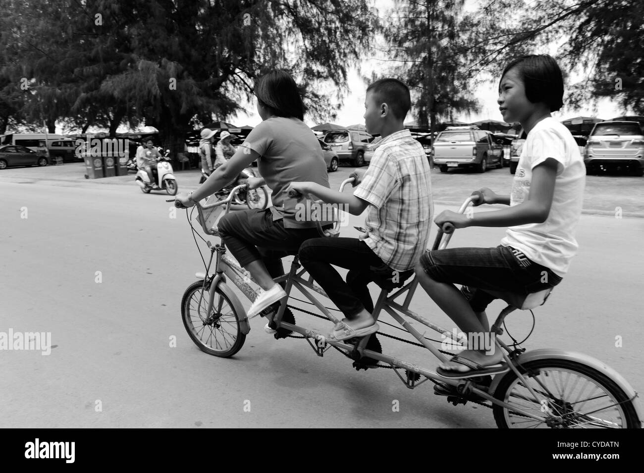 Tre persone in sella ad una bicicletta , spiaggia di Cha Am , cha am , della Thailandia Foto Stock