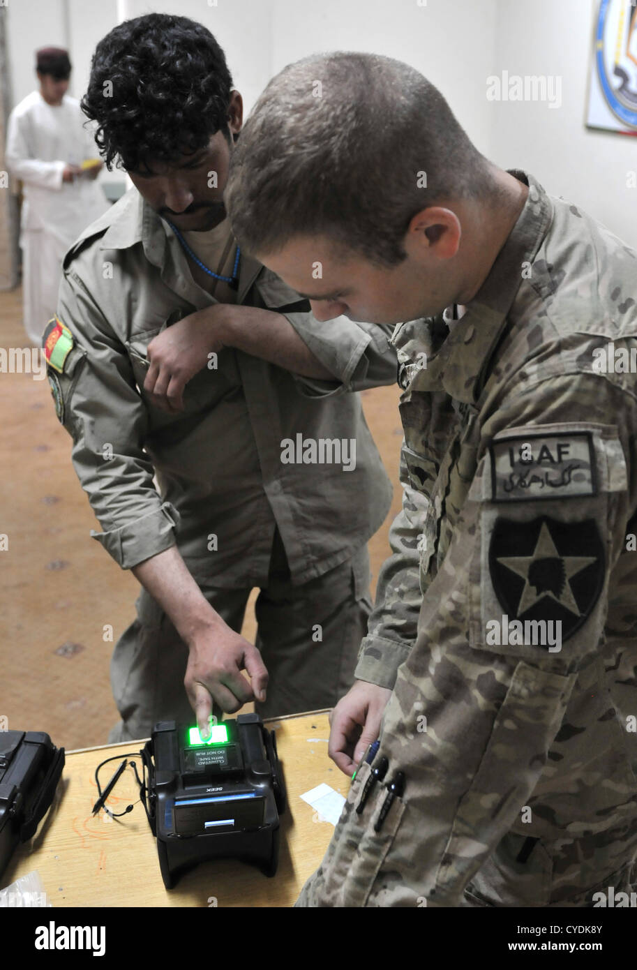 Un poliziotto afgano ha le sue impronte digitali scansionati sotto la supervisione della US Air Force 4 settembre 2012 nella provincia di Kandahar, Afghanistan. I militari USA ha utilizzato il nuovo Secure Electronic Enrollment Kit per scattare foto della polizia afgana del membro della retina e di colpi di testa di scansione e le loro impronte digitali. Foto Stock