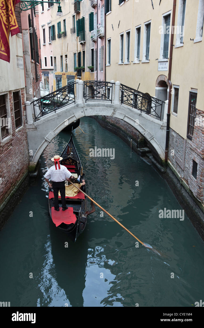 Gondoliere in attesa sulla gondola in un veneziano backwaters per traffico davanti per cancellare Foto Stock