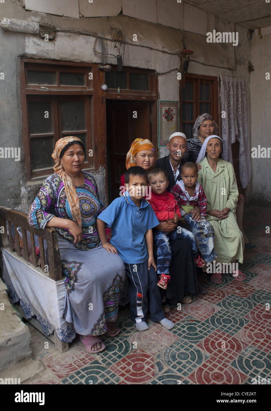 Uyghur famiglia al di fuori della loro casa, Minfeng, Xinjiang Uyghur Regione autonoma, Cina Foto Stock