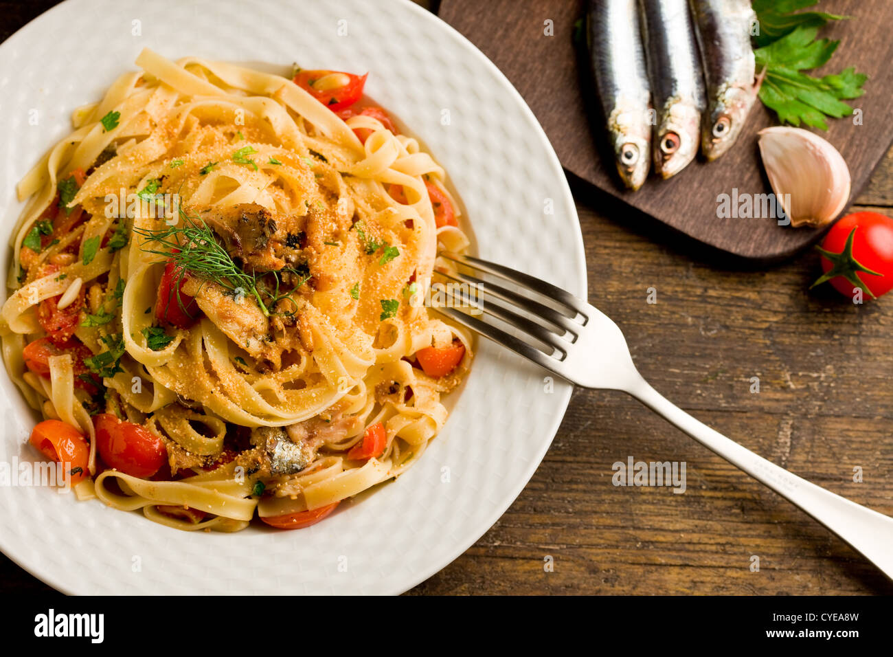 Regionale Italiana piatto a base di pasta con le sarde sul tavolo di legno Foto Stock