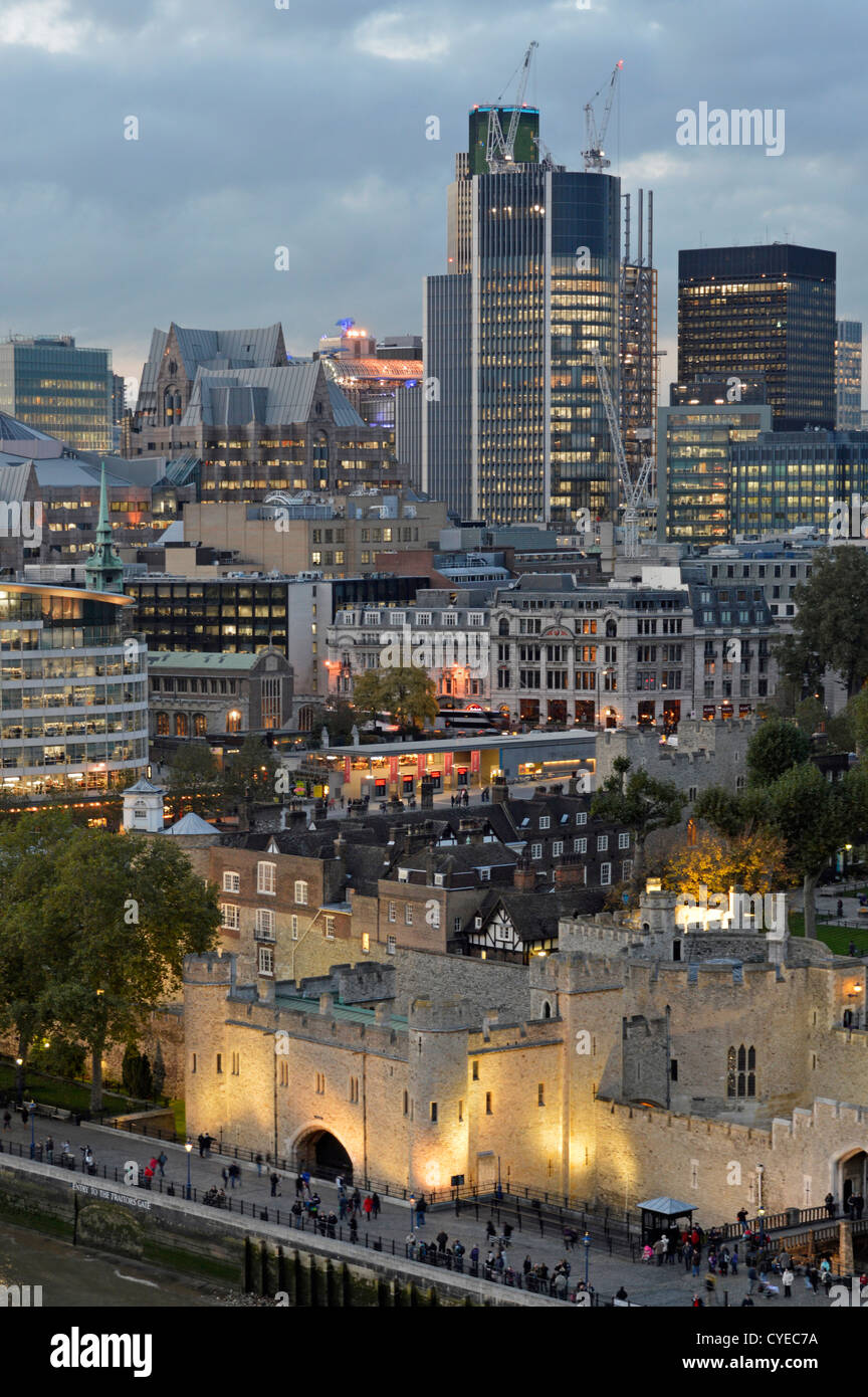I grattacieli simbolo della città di Londra dell'anno 2012 dominano lo skyline con illuminazione sulla storica Torre di Londra, Inghilterra, Regno Unito Foto Stock