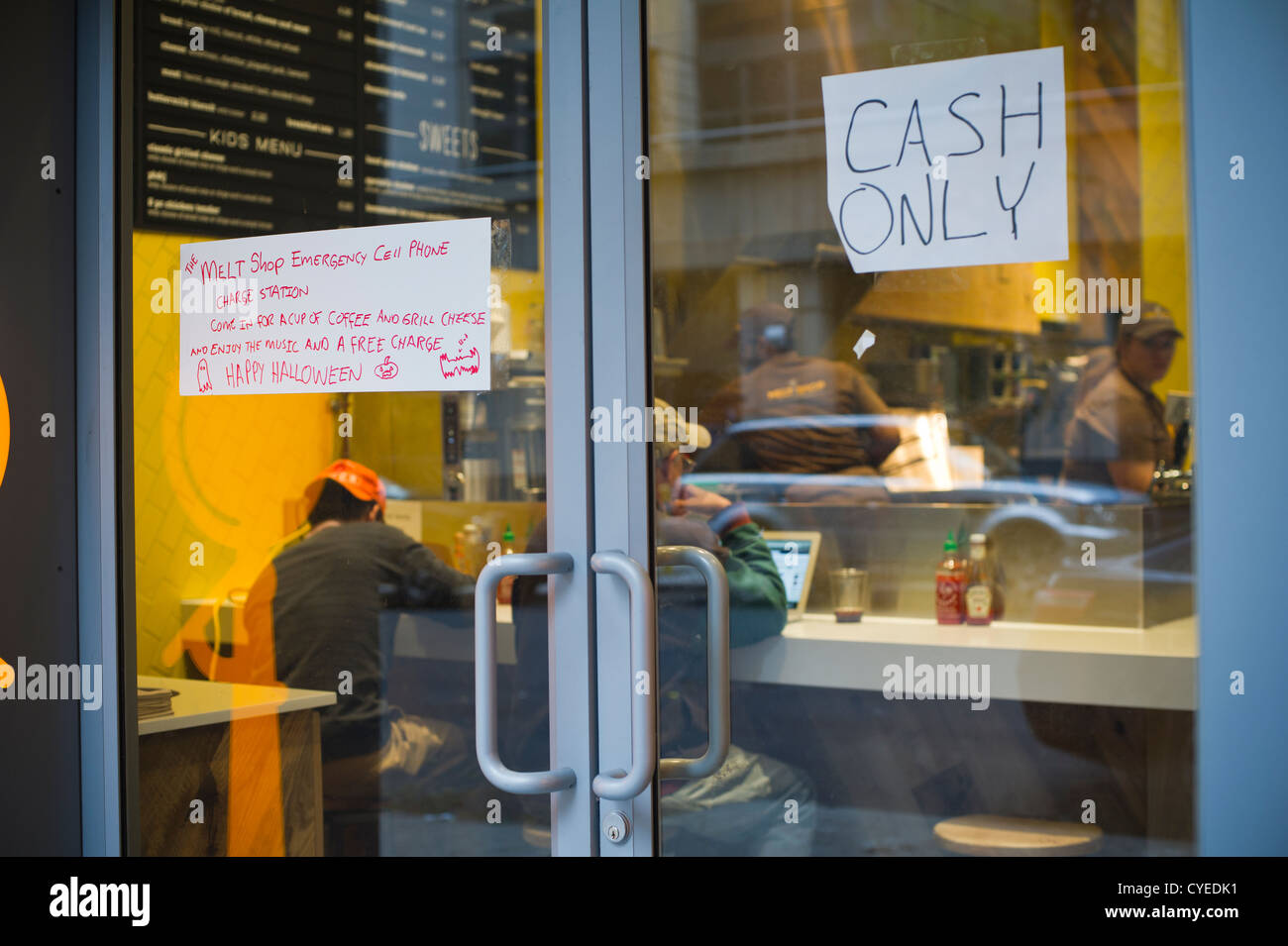 Un segno pubblicizza il negozio di fusione cellulare di emergenza telefono stazione di carica in corrispondenza di un Melt Shop ristorante nel quartiere di Chelsea di New York Foto Stock