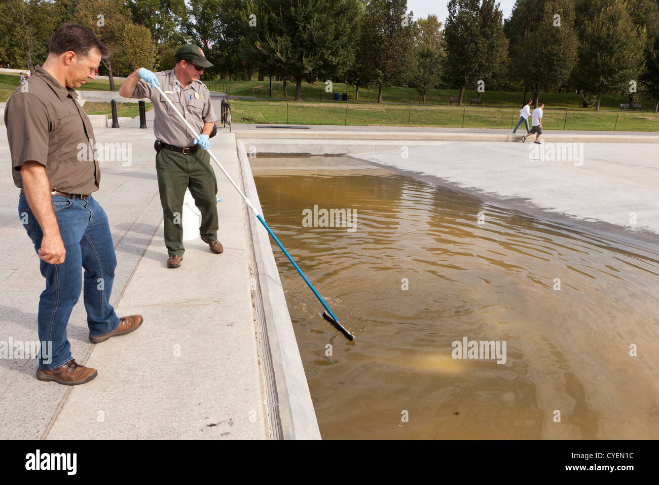 Lavoratore comunale pulizia fontana pubblica Foto Stock