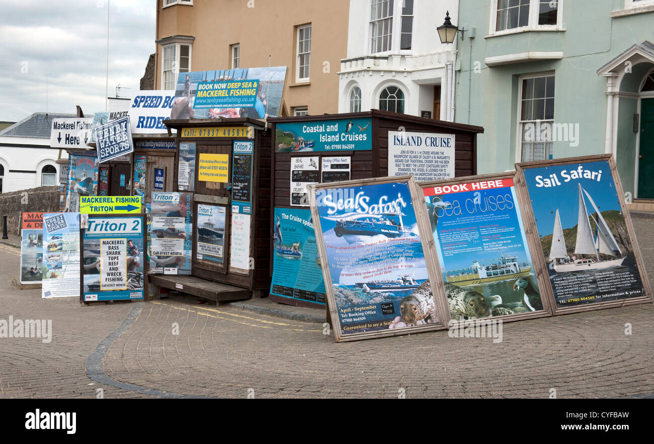 Gli uffici di prenotazione e annunci per gite in barca, Tenby Harbour, Pembrokeshire, nel Galles del Sud. Foto Stock