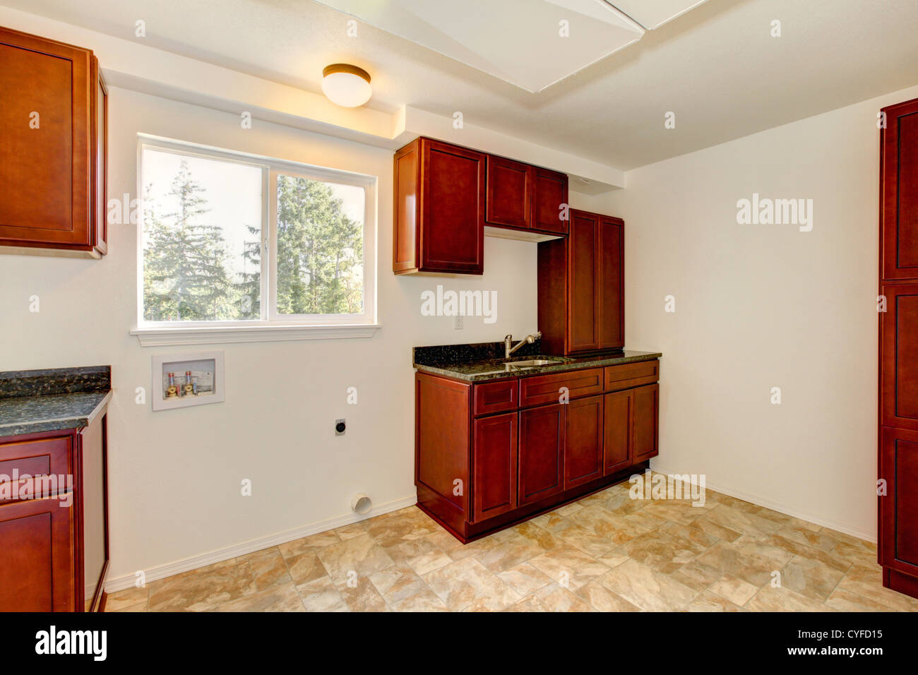 Bianco brillante nuova sala lavanderia con ciliegia scuro armadi. Foto Stock