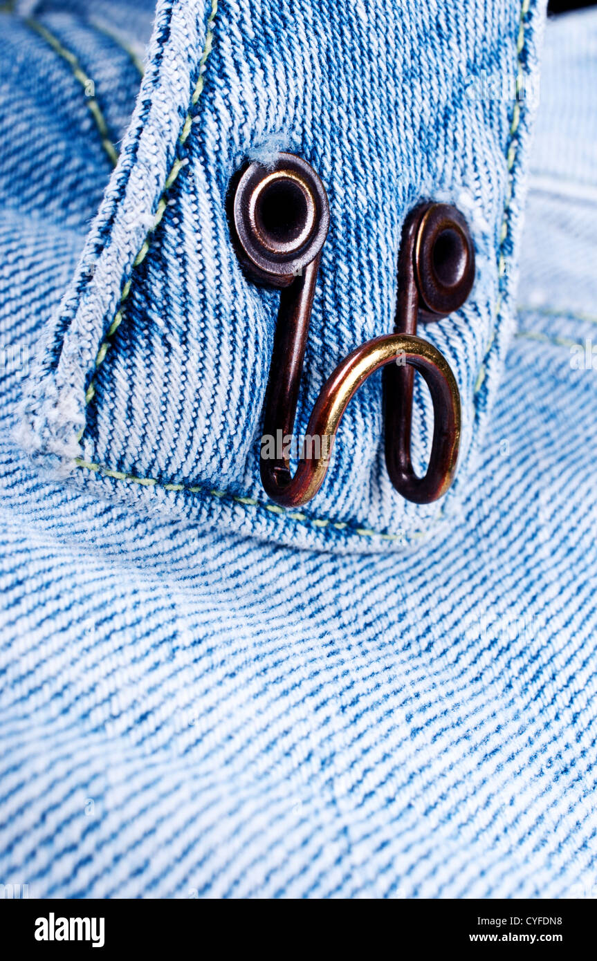 Usato pesantemente gancio sulla coppia di blue jeans pantaloni ottone Foto Stock