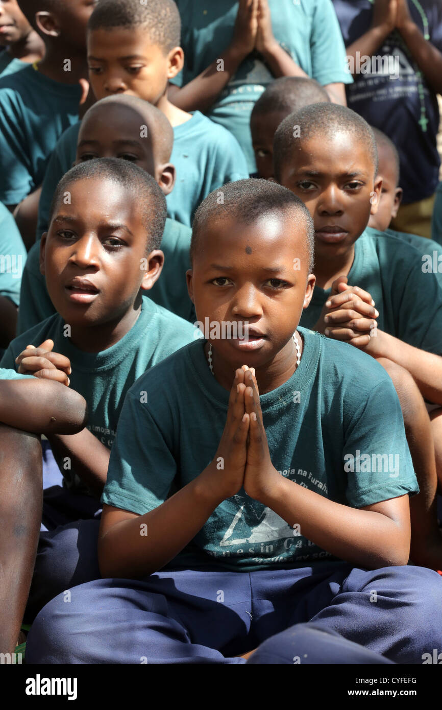Gli alunni pregare al termine di una formazione religiosa cattolica. Bagamoyo, Tanzania Foto Stock