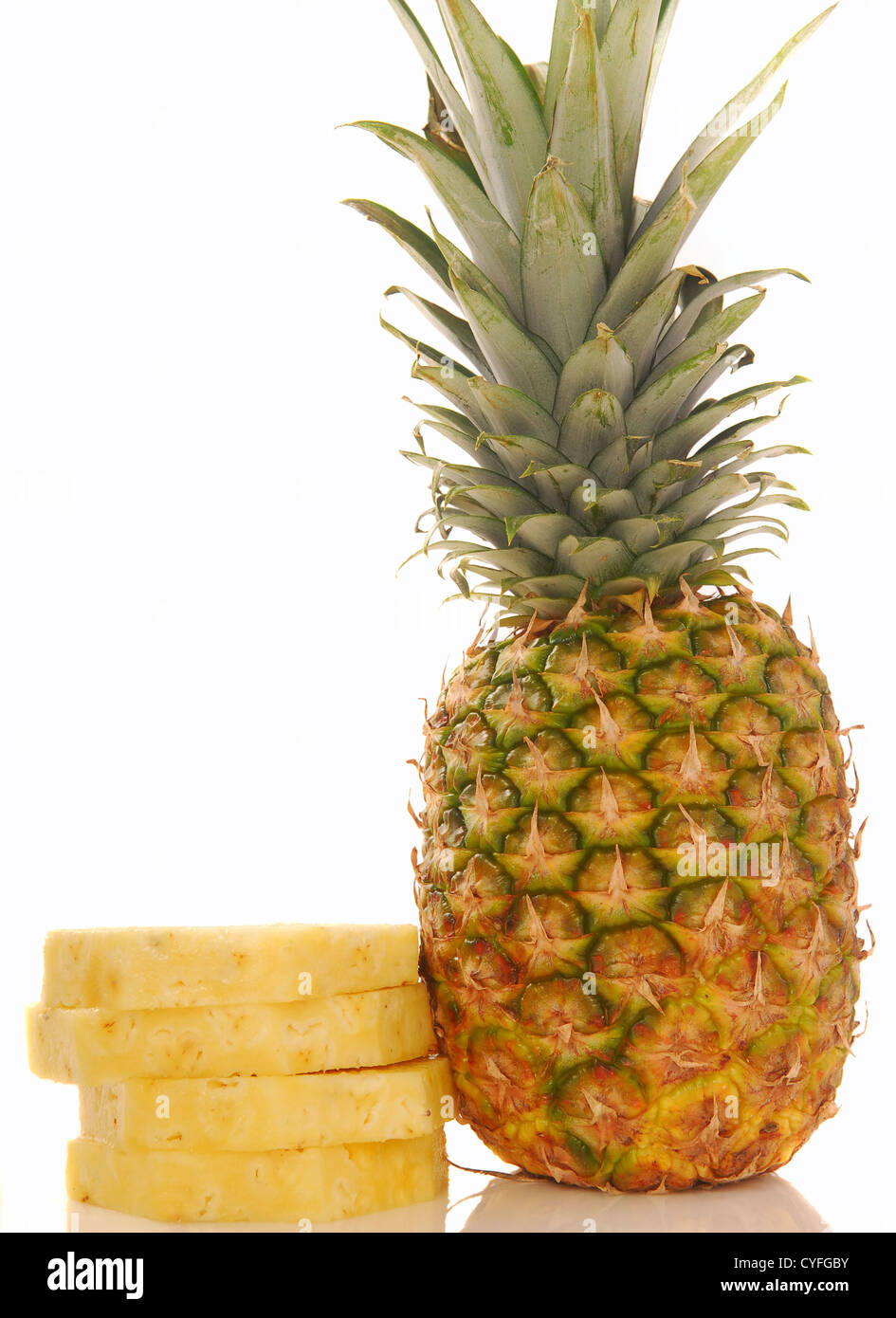 Fresche, intere Ananas tropicale con più strati impilati accanto ad essa su sfondo bianco Foto Stock