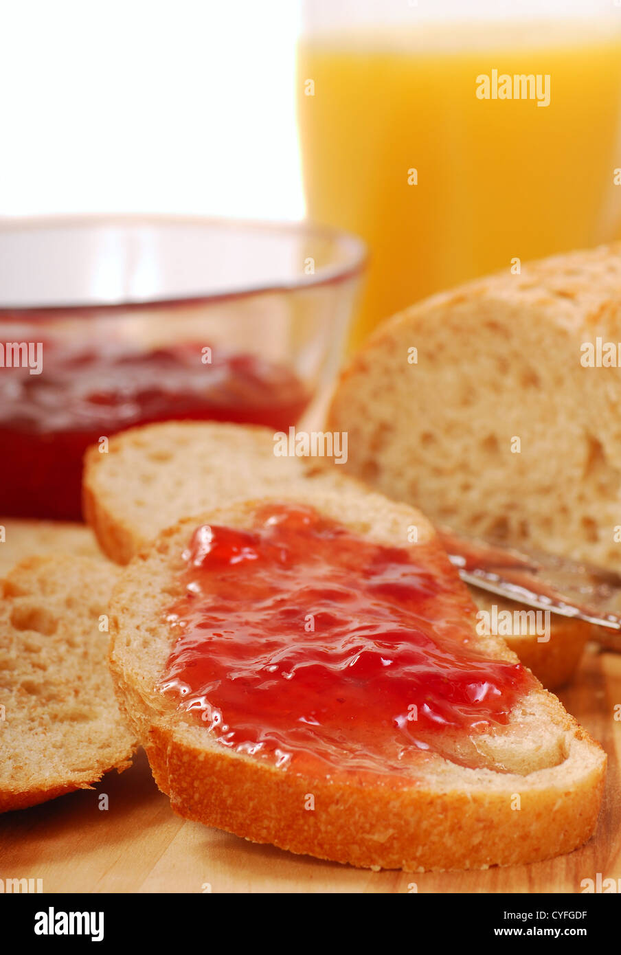 Delizioso pane appena sfornato con conserva di fragole e succo di arancia Foto Stock