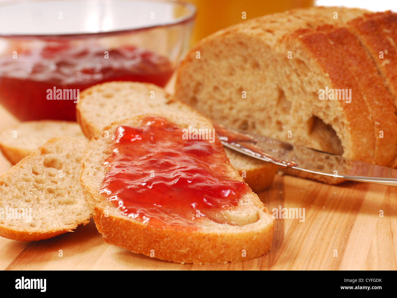 Delizioso pane appena sfornato con conserva di fragole e succo di arancia Foto Stock