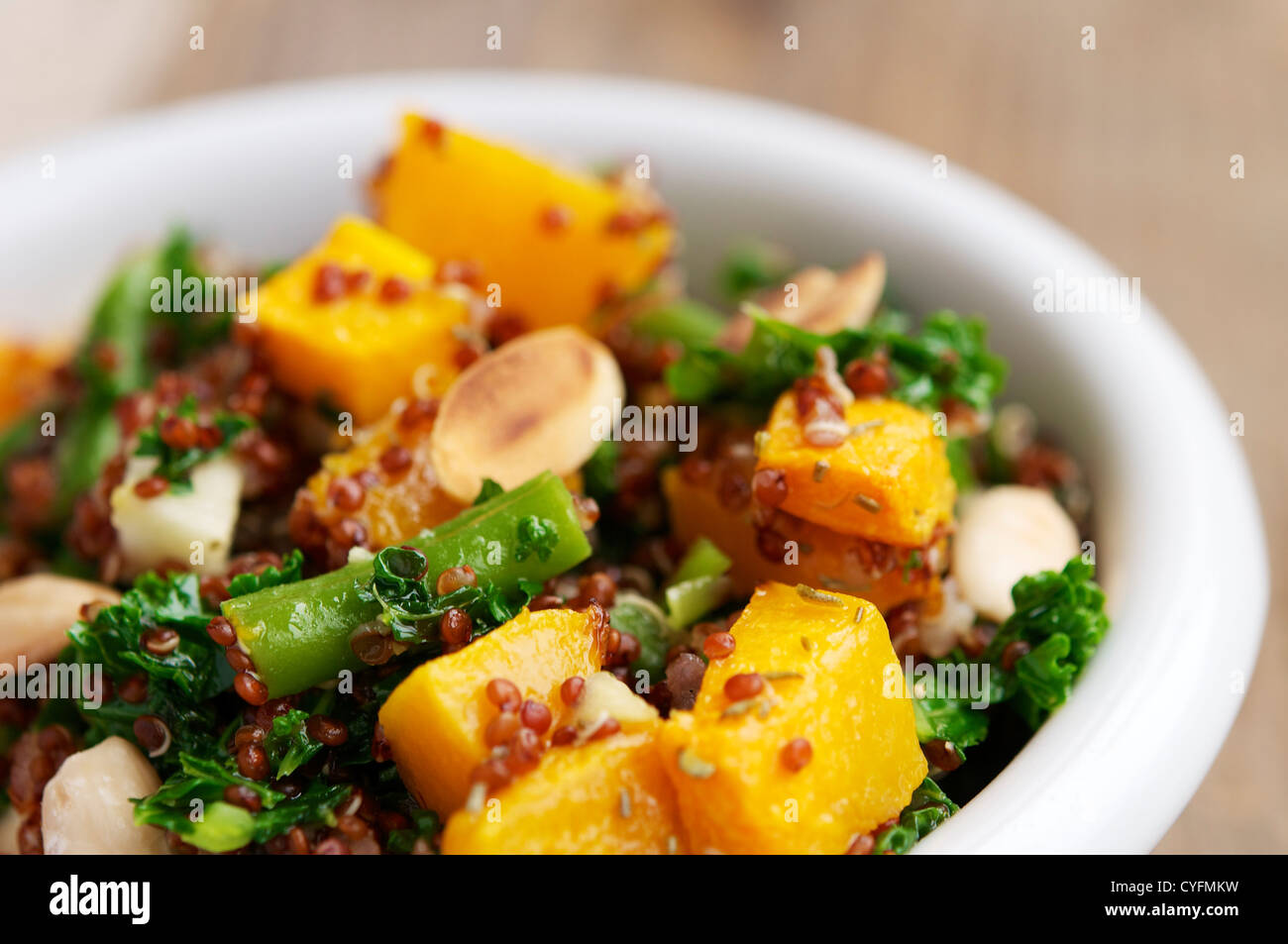 Un caldo con insalata di quinoa rossa, fagiolini, squash, kale, apple e mandorle. Foto Stock