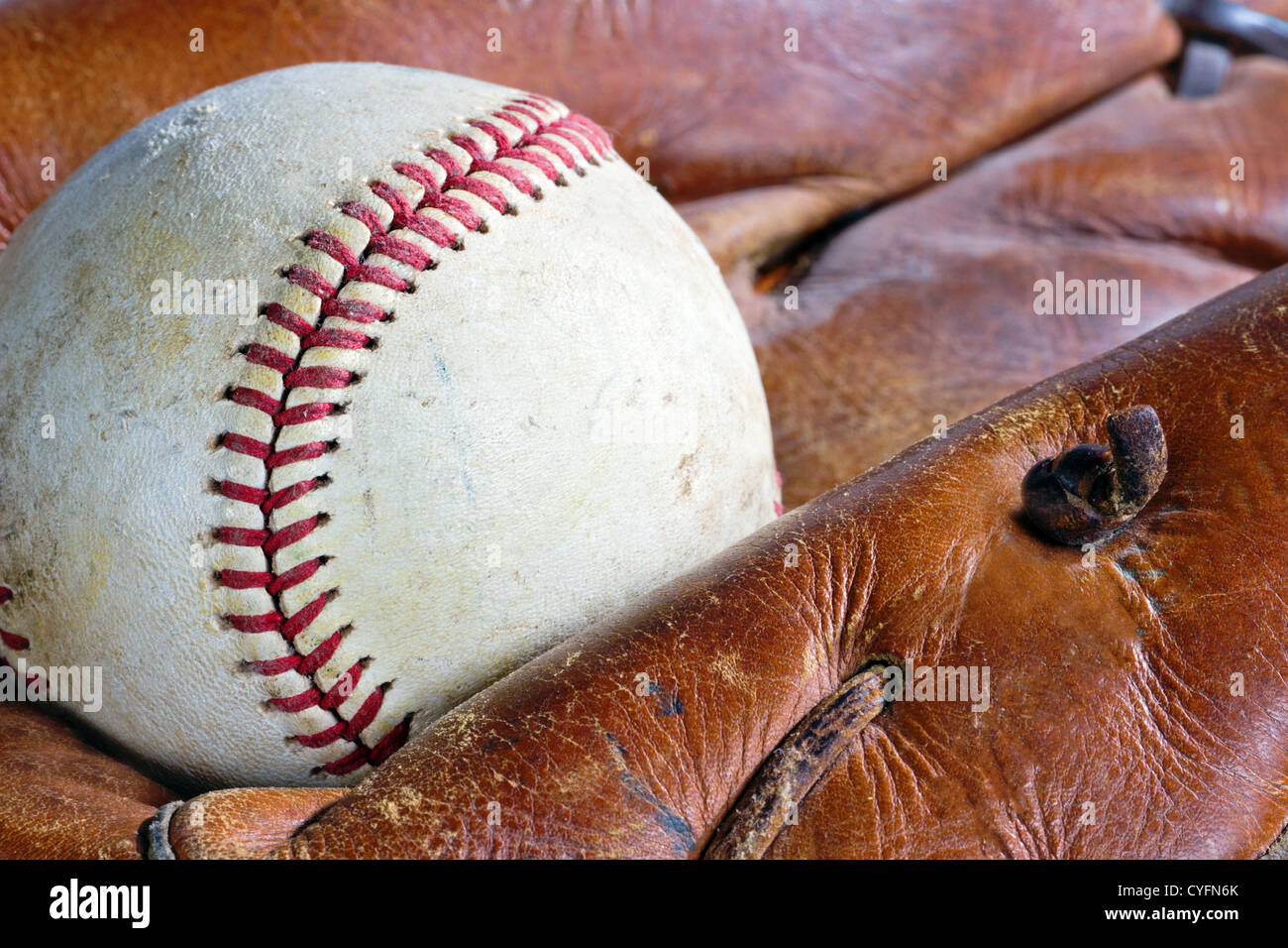Primo piano della vecchia e weathered baseball guanto in pelle e la sfera Foto Stock