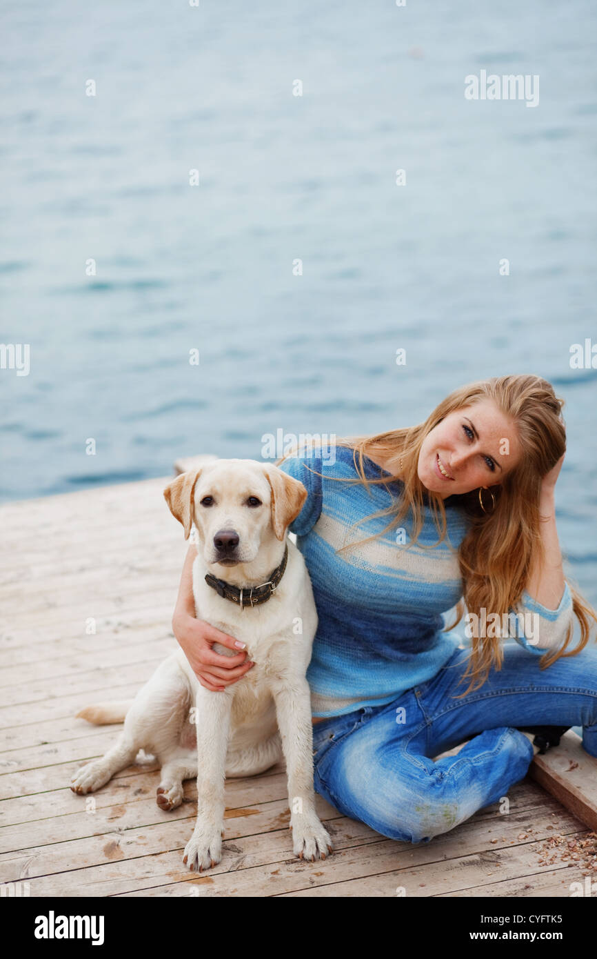 Bellissima ragazza con il suo cane sulla banchina vicino al mare Foto Stock