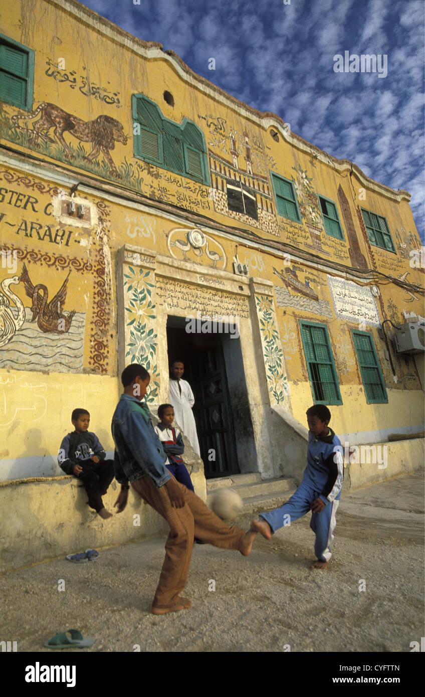Egitto Luxor sponda orientale della valle del fiume Nilo, i bambini a giocare a calcio davanti a loro graziosamente dipinto house. Foto Stock