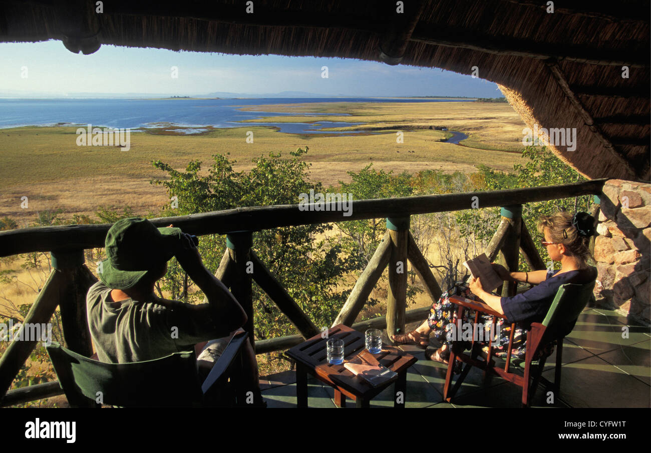 Lo Zimbabwe, nei pressi di Kariba, il lago Kariba, Katete Safari Lodge, turisti, lettura di donna e uomo con il binocolo Foto Stock