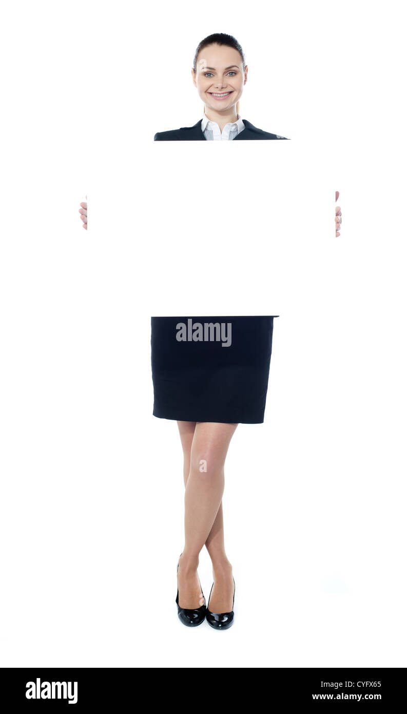 Ritratto di un felice giovane donna in possesso di un cartellone in bianco su sfondo bianco Foto Stock