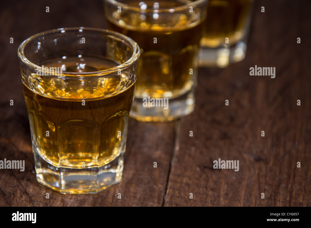 Scatti di rum in una linea su sfondo di legno Foto Stock