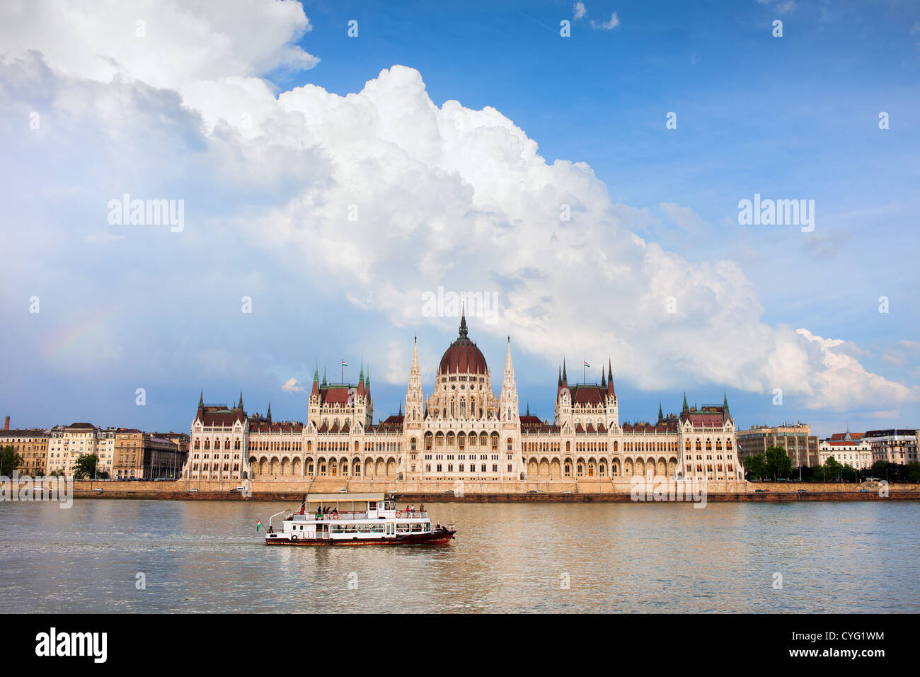 Budapest il palazzo del parlamento in Ungheria, fiume Danubio con nave passeggeri e drammatici del cielo. Foto Stock