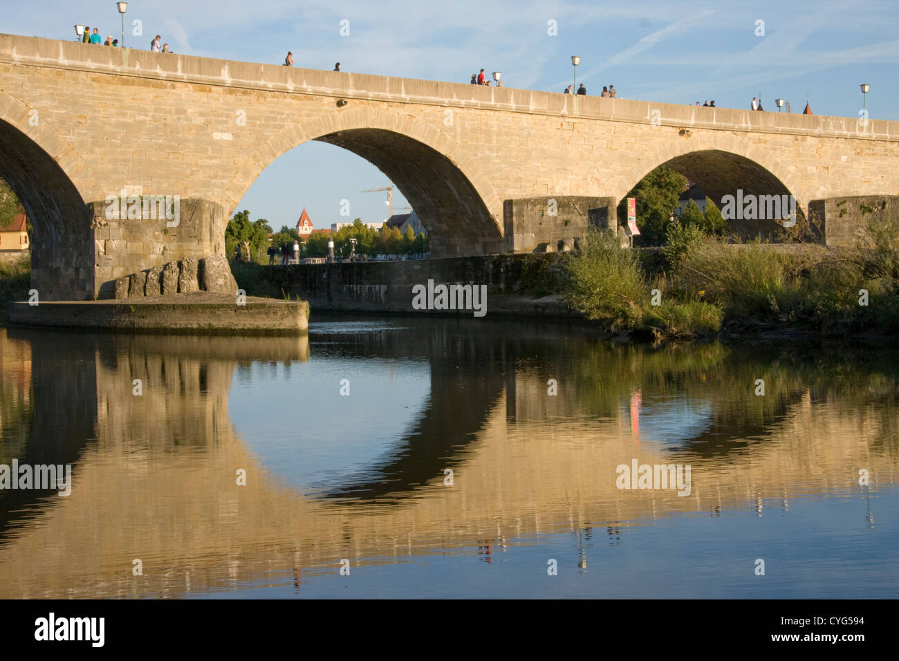Il XII secolo Steinere Brücke (ponte di pietra) riflesso nel fiume Danubio a Ratisbona, Baviera, Germania Foto Stock