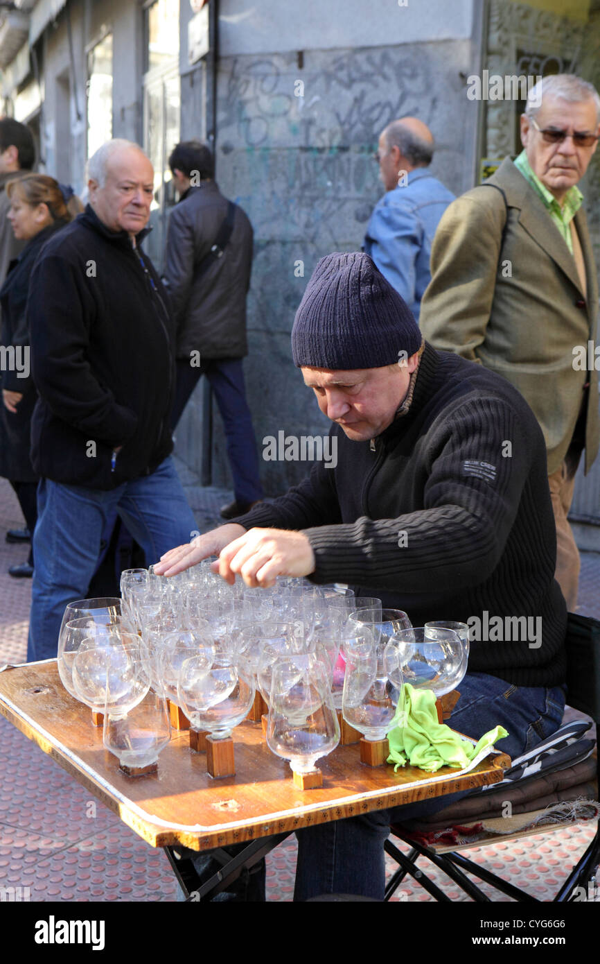 Uomo di mezza età di riproduzione di musica sull'arpa di vetro bicchieri di vino con quantità di acqua il mercato di El Rastro Madrid Spagna Europa Foto Stock