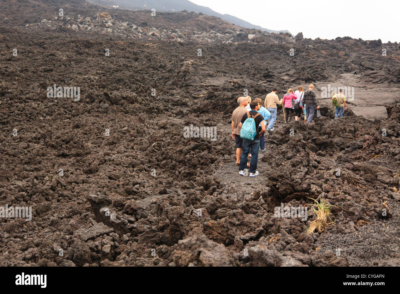 I turisti del trekking attraverso la terra bruciata dalla lava espulsa dal vulcano Pacaya, nelle vicinanze di Antigua, Guatemala. Foto Stock