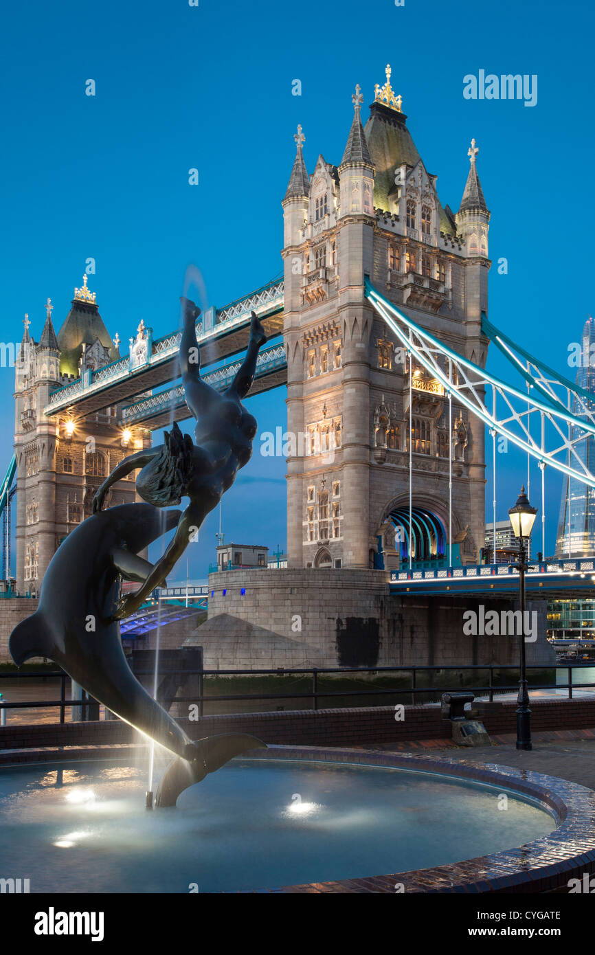 David Wynne della ragazza con una statua di delfini al di sotto del Tower Bridge, Londra Inghilterra, Regno Unito Foto Stock